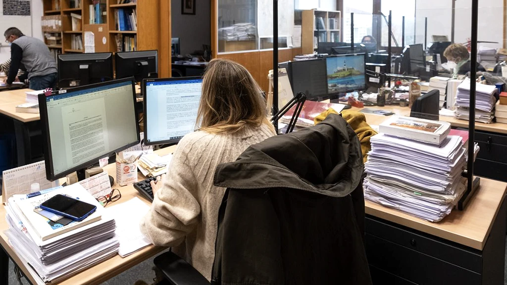 Trabajadora de la Xunta administrando una gran carga de gestión documental en el proceso de expedientes donde se identifican cuellos de botella